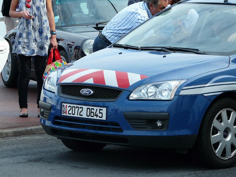 P1050342.JPG - Ils se tiennent à carreau et ils ont raison. Le maire (chef des poteaux) négocie avec les autorités. Les bleus roulent en ford.Probablemant, un reste du débarquement, bien que Villers fut libéré par les canadiens. Une voiture noire est tapie sur le trottoir.